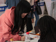 正在登記表上簽字的學生