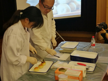 專家在對月餅進行稱重并分析餡料比