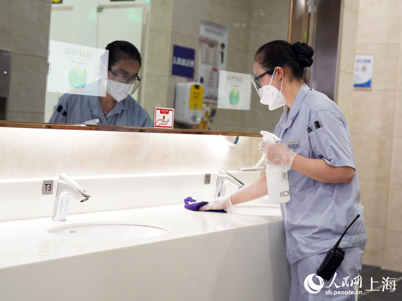 保潔員在上海虹橋火車站對廁所間洗手臺進行擦抹消毒作業。
