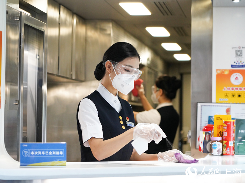 隨車餐飲乘務員在餐車吧臺進行消毒作業。