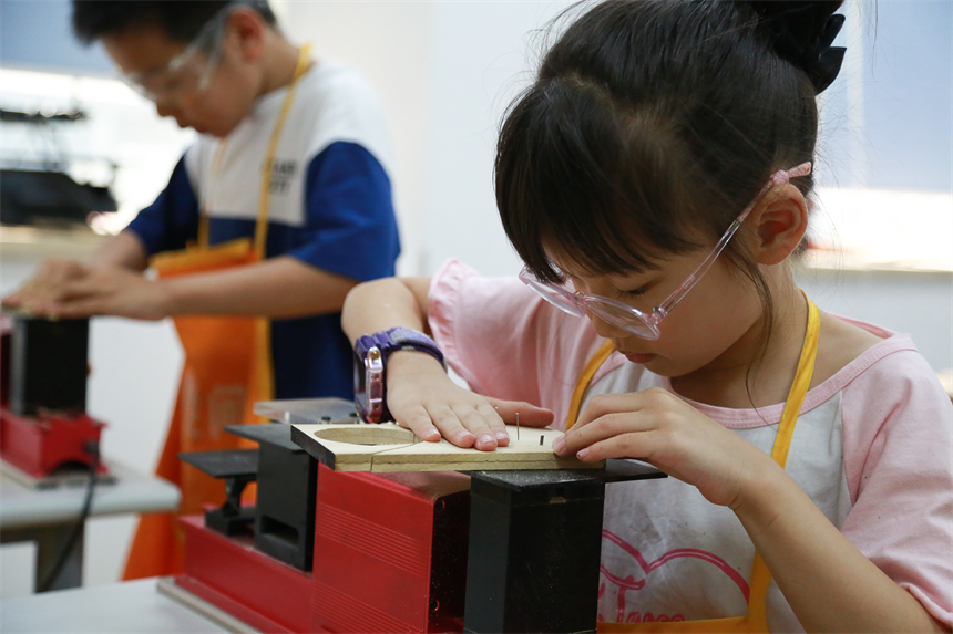 上海市青少年活動中心的童創空間課程上，學員正在做木藝切割。