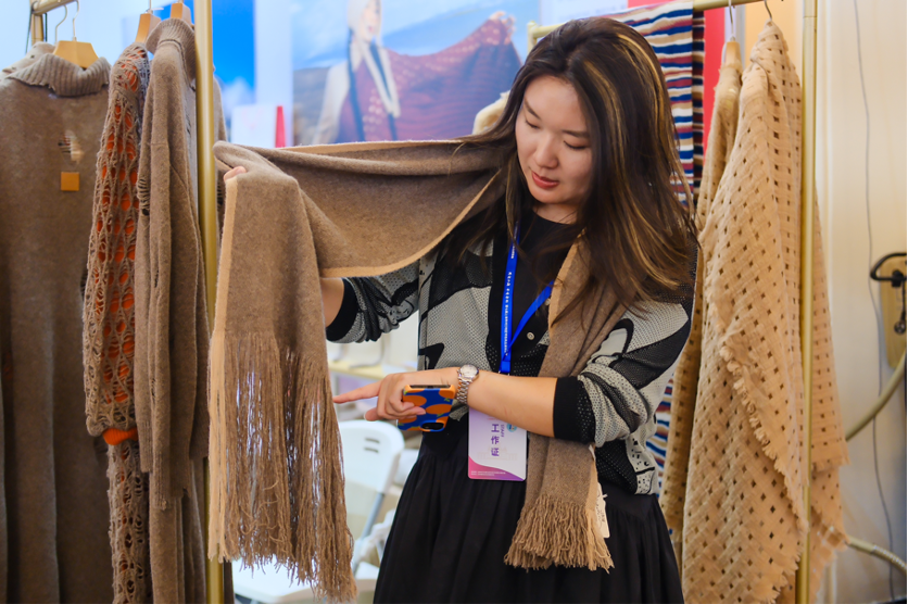 工作人員展示青海果洛牦牛絨圍巾。青海果洛州是青海重要牧業生產基地，擁有青海最大的原始森林。作為青藏高原特有物種，牦牛在廣袤的高原牧場上自由生長。14年來，上海先后派出五批次援青干部人才，強力推動了果洛牦牛這一特色產業發展，各式各樣的牦牛產品陸續走進上海市場。