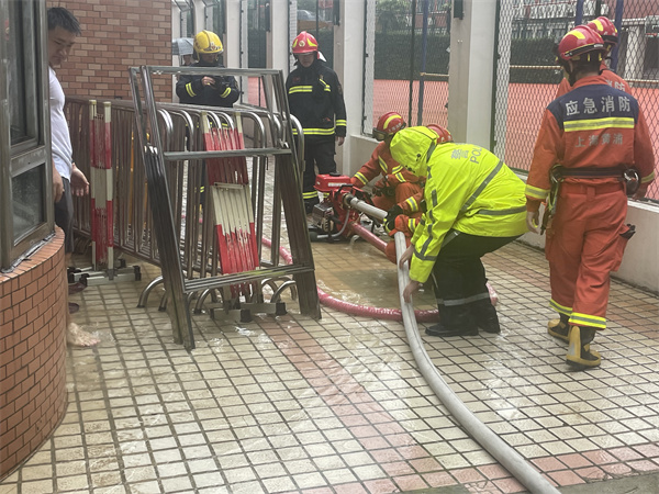 打浦橋派出所民警與消防配合處置排出海華小學校內積水。