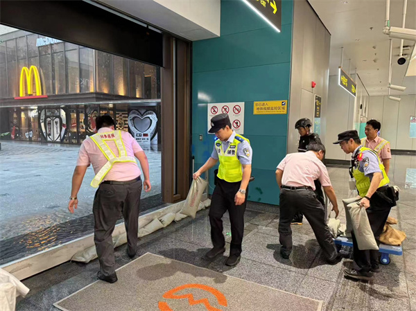 軌道公交總隊徐家匯站治安派出所民警、輔警會同車站工作人員在上海南站站9號口鋪設擋水板及阻水沙袋防止雨水倒灌。