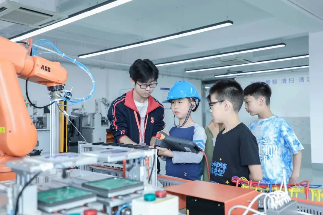 上海市工業技術學校的工業機器人項目，吸引了參加職業體驗日活動的小學生。