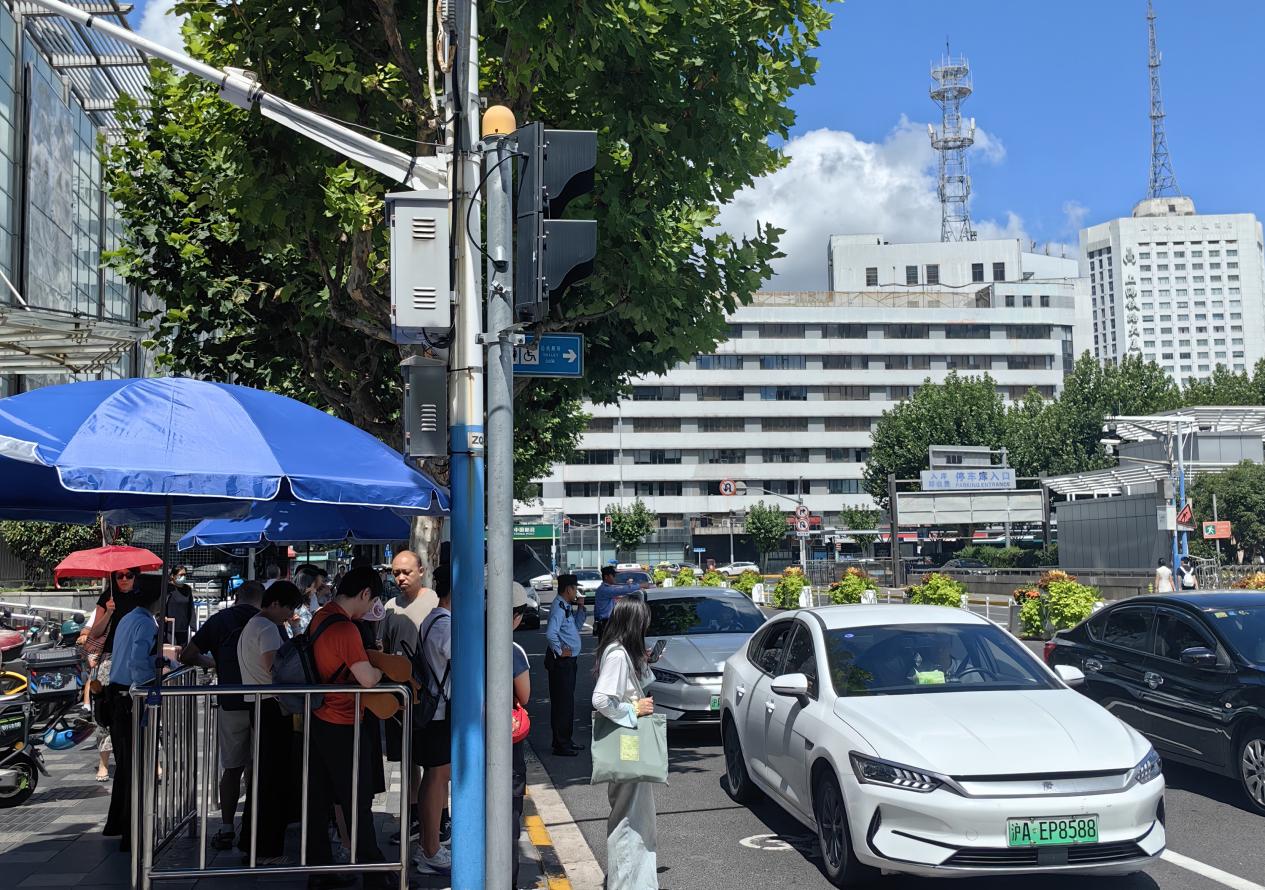 南2網約車上客點，乘客在工作人員引導下排隊候車。唐小麗攝